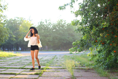 Full length of woman standing on footpath