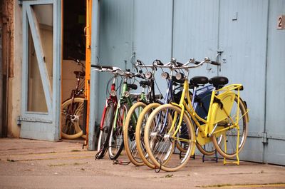 Bicycles parked on footpath against wall