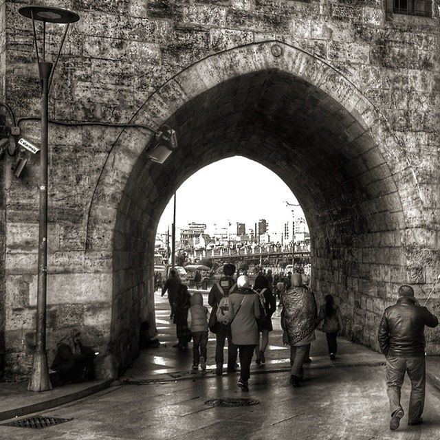 architecture, arch, men, built structure, person, walking, lifestyles, full length, large group of people, leisure activity, building exterior, archway, rear view, city life, city, indoors, the way forward, street, tourist