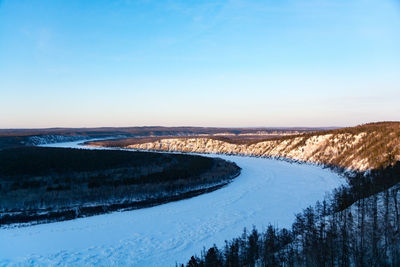 Scenic view of snow covered land against blue sky