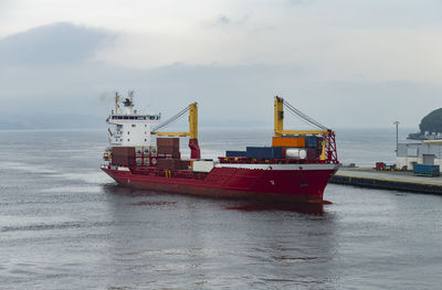 The photo shows a cargo ship docking in the harbor of bergen