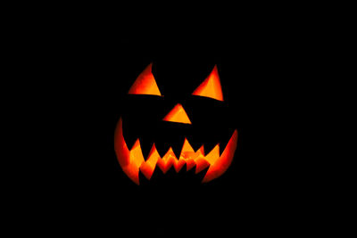 Close-up of illuminated pumpkin against black background