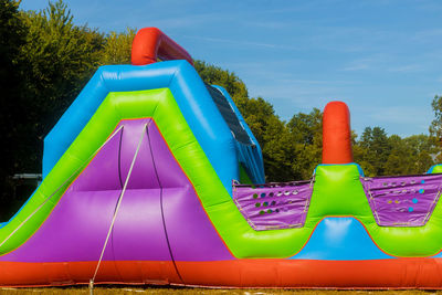 Multi colored playground against blue sky