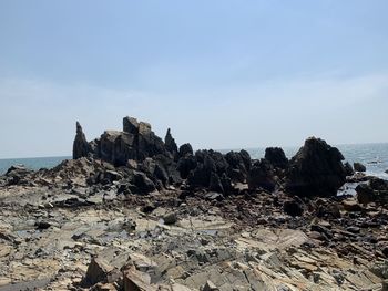 Rocks on beach against sky