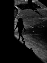 High angle view of girl walking on footpath at night