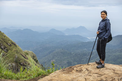 Woman standing on top of adam's peak close to ella in sri lanka