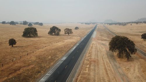 Road amidst field against sky