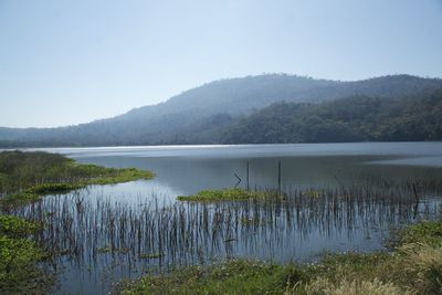 Scenic view of lake by mountains against sky