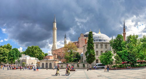 Panoramic view of buildings in city against cloudy sky