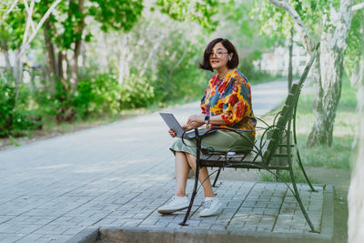 Serene outdoor office scene with a relaxed woman using her computer in nature
