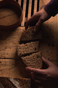 Cropped hand of person artesian bread on table