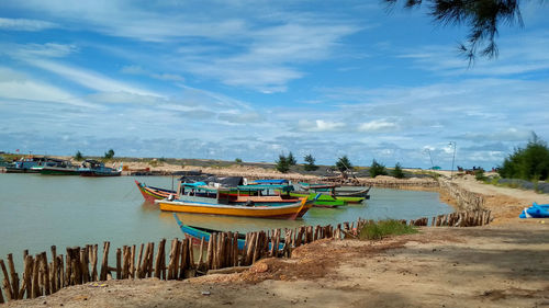 Boats moored on beach against sky