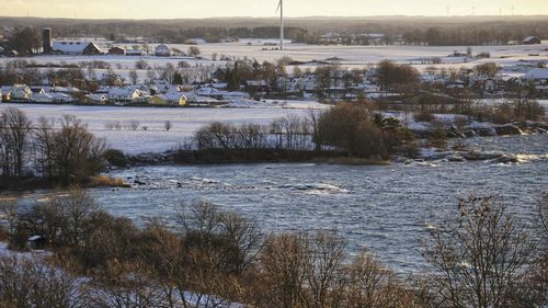 Scenic view of river against sky during winter