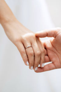 Cropped hand of person gesturing against white background