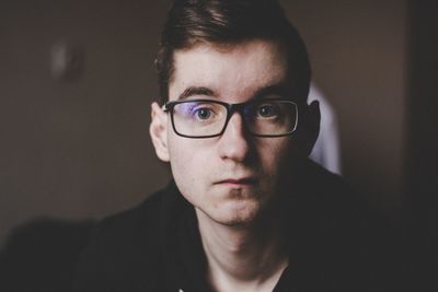 Portrait of young man wearing eyeglasses at home