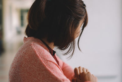 Side view of woman in corridor against wall