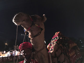 Midsection of woman against illuminated sky at night