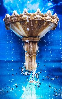 Close-up of water splashing on blue table