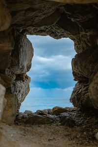 Rock formation on beach against sky