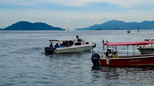 Boats sailing in sea against sky