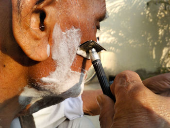 Close-up of man shaving beard