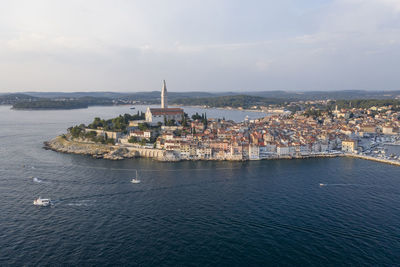 High angle view of townscape by sea against sky