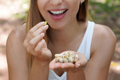 Midsection of woman holding seashells