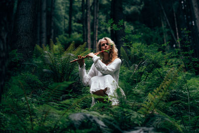 Rear view of woman standing in forest