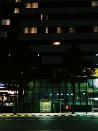 Illuminated building by street at night