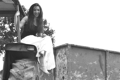 Portrait of smiling young woman sitting outdoors