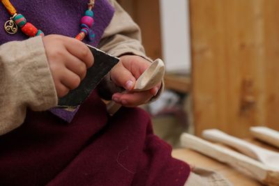 Midsection of woman holding wooden spoon