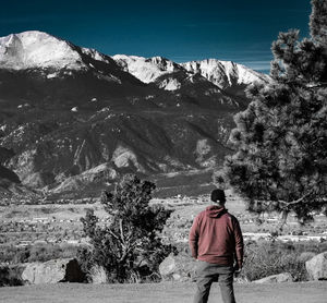 Rear view of man standing on snow covered landscape