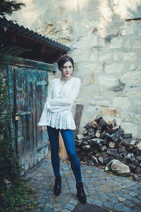 Beautiful girl in a white lace blouse and jeans near the farmer house. spring or summertime 