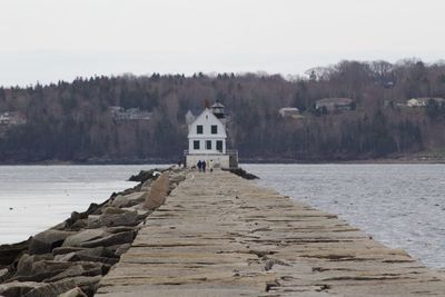 Pier amidst lake and buildings against sky