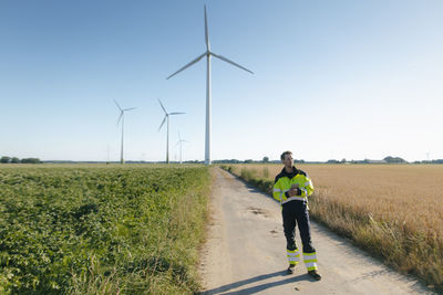 Engineer standing on field path at a wind farm