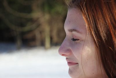 Close-up side view of smiling woman with eyes closed outdoors