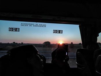 People in bus against sky during sunset