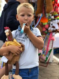 Close-up of boy holding toys while standing outdoors