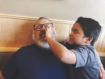 Boy and father playing against wall at home