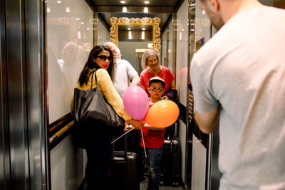 Family looking at man while standing in elevator