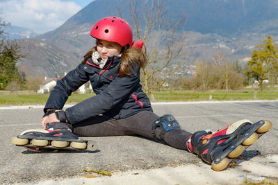 Full length of teenage girl sitting on road