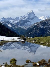 Scenic view of snowcapped mountains by lake against sky
