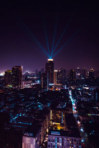 Illuminated cityscape against sky at night