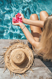 Midsection of woman sitting in swimming pool