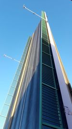 Low angle view of modern building against clear blue sky