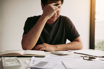 Man with head in hands sitting on table at home