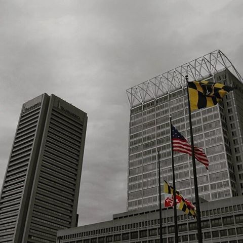 building exterior, architecture, built structure, low angle view, city, skyscraper, sky, modern, tall - high, office building, tower, building, cloud - sky, development, flag, glass - material, day, cloudy, crane - construction machinery, american flag
