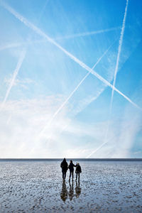 People on beach against sky