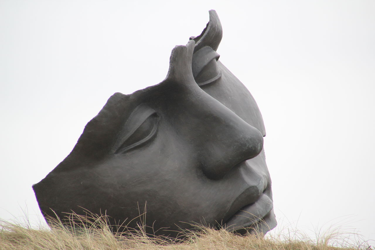 CLOSE-UP OF STATUE AGAINST SKY