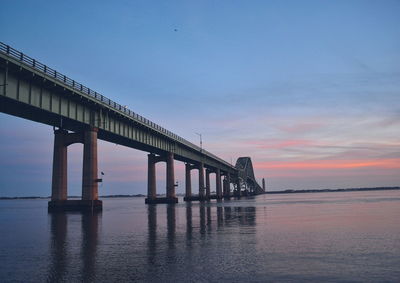 Scenic view of bridge over sea against sky during sunset
